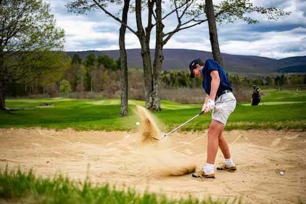 Junior golfer Caeden Herrington works his way out of a bunker during a lesson at Manchester Country Club (VT)