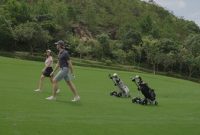 picture of the autonomous ROBERA AI Golf Caddy following behind golfers walking in fairway.