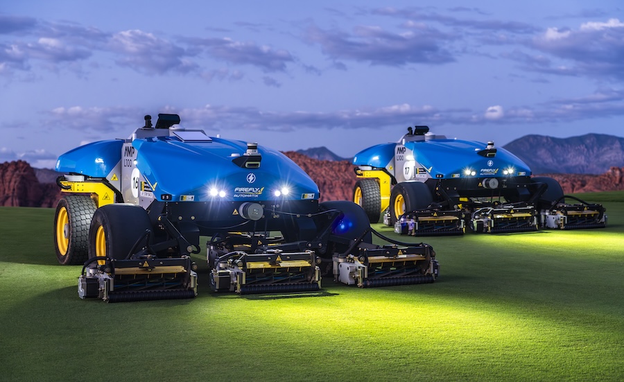 Two Stationary AMP Mowers on golf course at dusk